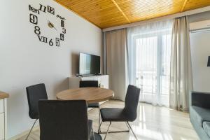 a dining room with a table and chairs and a clock at Willa Groszek in Jastarnia