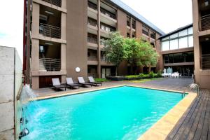 una piscina di fronte a un edificio di The Nicol Hotel and Apartments a Johannesburg