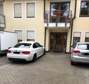 deux voitures blanches garées devant un bâtiment dans l'établissement Apartment nahe Siemens Campus, à Erlangen