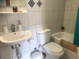 a bathroom with a toilet and a sink and a tub at Heaven Studios & Apartments in Stalís