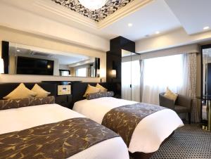千葉市にあるアパホテル〈千葉駅前〉のベッド2台とテレビが備わるホテルルームです。