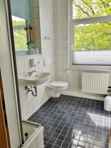 uma casa de banho com um lavatório, um WC e uma janela. em Hotel Zittauer Hütte em Kurort Jonsdorf