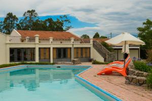 a house with a swimming pool and an umbrella at Hosteria La Caldera in La Caldera
