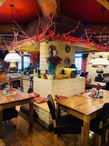 un restaurante con mesas de madera y adornos rojos en Hotel Korona en Kłodzko