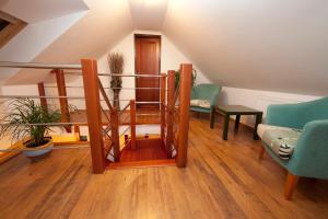 een woonkamer met een trap met stoelen en een tafel bij Penzión Vila Dalí in Rajecké Teplice