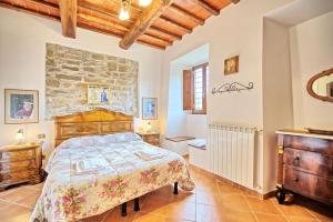 a bedroom with a bed and a stone wall at Agriturismo Fattoria Celle in Figline Valdarno +85 photos
