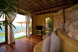 a living room with a couch and a rock wall at View Point Resort in Ko Tao