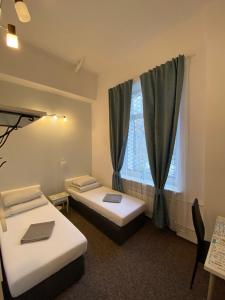 a room with two beds and a window at Pastel Guest Rooms in Warsaw