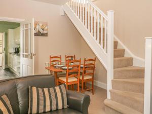 a living room with a table and chairs and a staircase at Brinks View Cottage in Hope