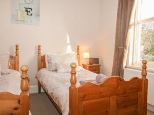 a bedroom with two wooden beds and a window at Brinks View Cottage in Hope