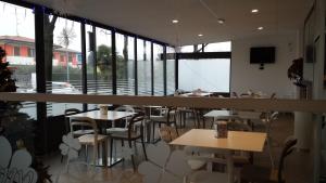 a restaurant with tables and chairs and a large window at Sony Affittacamere in Desenzano del Garda