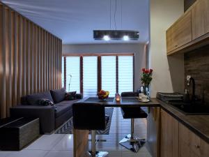 a kitchen and living room with a couch and a table at 4UApart-Apartment studio Platan New York in Świnoujście