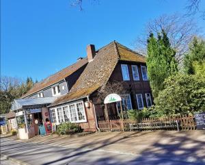 a large house with a store on a street at Landhotel Heidkrug in Munster im Heidekreis