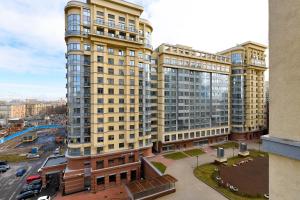 un edificio alto amarillo con una calle delante en Rentalspb Apartment Graf Orlov en San Petersburgo