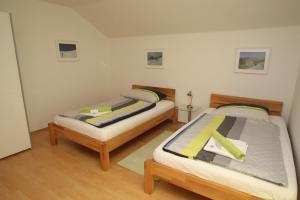 two twin beds in a room with wooden floors at HH-Apartments in Scheifling