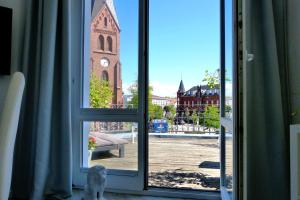 a dog sitting in front of a window looking at a church at Residenzen am Kirchenplatz in Warnemünde