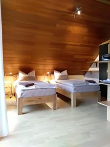 two beds in a room with a wooden ceiling at Haus Alexandra in Bad Driburg