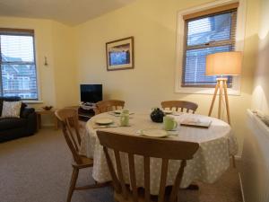 a living room with a table with chairs and a couch at Star Fish Apartment in Weymouth