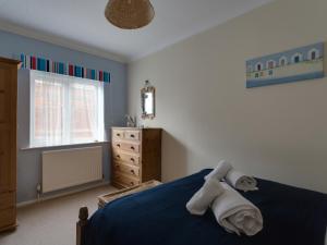 a bedroom with a blue bed with towels on it at Star Fish Apartment in Weymouth