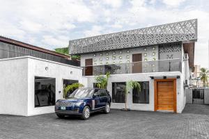 ラゴスにあるVilla Monument Hotelの建物の前に駐車された青い車