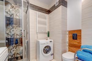 a bathroom with a washing machine and a toilet at Nadmorski Szept in Dziwnówek