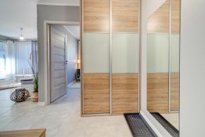 a pivot door in a living room with wood and glass at Nadmorski Szept in Dziwnówek