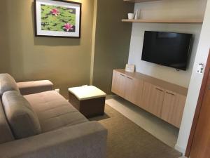 a living room with a couch and a flat screen tv at Apartamentos Caldas Novas in Caldas Novas