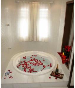 uma casa de banho com uma banheira cheia de flores vermelhas em Apartamentos Caldas Novas em Caldas Novas