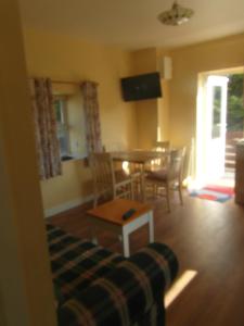 a living room with a couch and a table and chairs at Country Studio in Portarlington