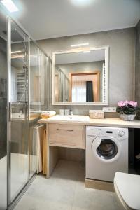 a bathroom with a washing machine and a sink at Koral in Mielno