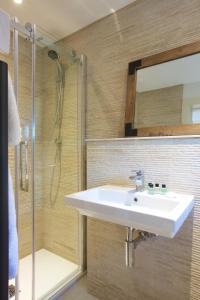 uma casa de banho com um lavatório e um chuveiro em Railway Apartments em Nailsworth