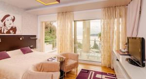a bedroom with a bed and a tv and a window at Meridian Hotel in Budva