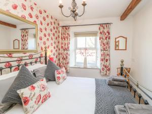a bedroom with a large bed and a window at Middle Cottage in Leyburn