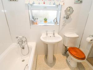 a bathroom with a toilet and a sink and a tub at Middle Cottage in Leyburn +23 photos