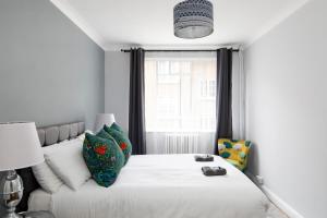 a bedroom with a white bed and a window at Marylebone Apartments in London