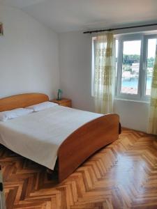 ein Schlafzimmer mit einem großen Bett und einem Fenster in der Unterkunft Apartment Davor - parking in Sali