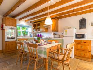 a kitchen with a table with chairs and a refrigerator at Townfoot Cottage in Elsdon