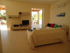 a living room with a couch and a tv at Katikies 20 in Pissouri