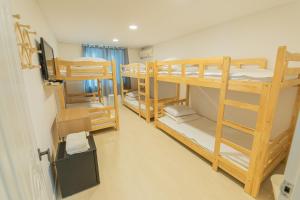 um quarto com 3 beliches num dormitório em James Blue Hostel em Sokcho