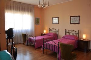una camera da letto con due letti, una tv e una finestra di Giangurgolo B&B a Rende