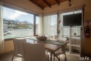 une salle à manger avec une table et une grande fenêtre dans l'établissement Departamentos La fe, à Ushuaia