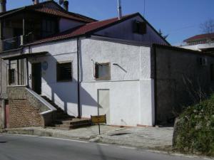 a small white building with a door and a staircase at B&B Ixia in Carolei