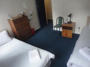 a bedroom with a bed, chair, desk and a television at Royal Chambers Liverpool in Liverpool