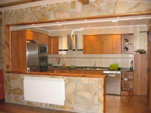 a kitchen with wooden cabinets and stainless steel appliances at Legaire Etxea in Ibarguren