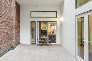 a room with a brick wall and a glass door at Abode Los Angeles - Downtown Historic Core in Los Angeles