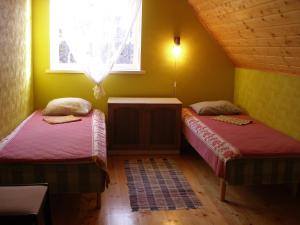 two beds in a room with a window at Andrese Holiday Home in Muratsi