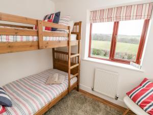 a bedroom with two bunk beds and a window at Buffers in Whitby