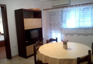 Apartments Darko - 100m from sea في فير: غرفة طعام مع طاولة وتلفزيون