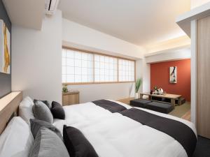 a bedroom with a large white bed and a couch at MIMARU Tokyo Shinjuku West in Tokyo