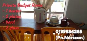 a dining room table with two chairs and a blender at Arina`s Homestay in Kampung Kuala Besut